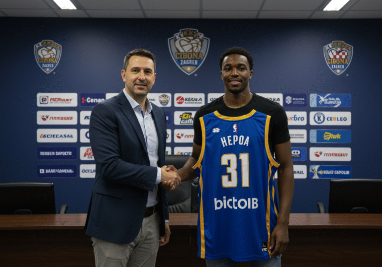 A 25-year-old athletic American man, Kamake Hepa, in a new KK Cibona Zagreb basketball jersey, shaking hands with a Croatian club official in a business suit. They are standing in a well-lit, professional office or press area within the KK Cibona VIP club headquarters in Zagreb, Croatia. The background features subtle branding with the club's logo and team colors. Hepa is smiling confidently, looking towards the camera, while the official is looking at him with a welcoming expression. It is a bright, clear day, and the atmosphere is formal and optimistic.