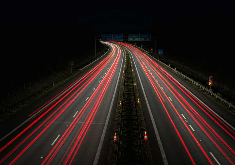 An editorial photograph captured at night on the Croatian A1 highway, looking along the 419th kilometer section between the Šestanovac and Zagvozd interchanges, in the direction of Dubrovnik. Traffic is moving slowly in a single lane, marked by temporary orange traffic cones and small yellow flashing lights on the pavement. The scene is illuminated by vehicle headlights and taillights, casting long streaks of red and white light on the asphalt. The surrounding area is dark, characteristic of a rural highway in the evening. The atmosphere conveys caution and reduced speed.